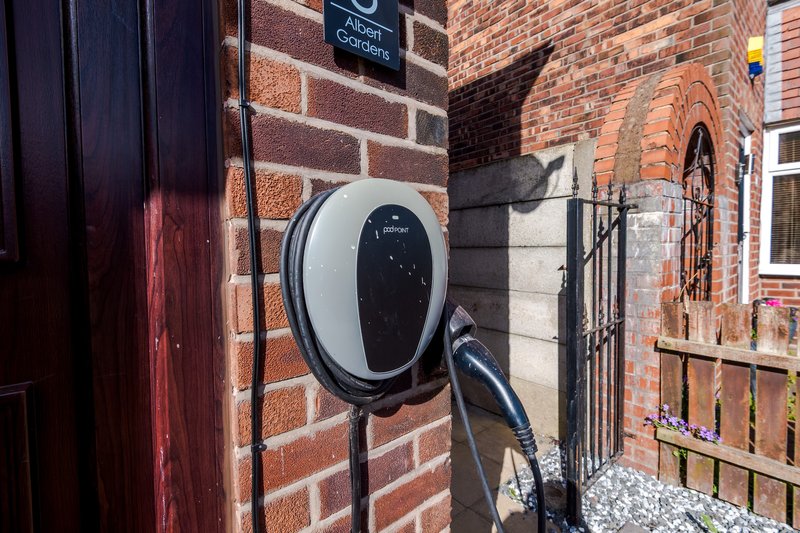 Brick exterior with electric vehicle charging point mounted on wall