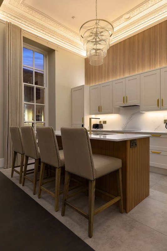 Modern kitchen with island, bar seating, pendant lighting and floor-to-ceiling window
