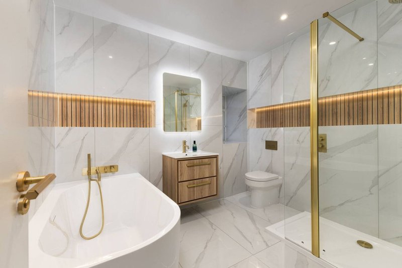 Modern bathroom with marble walls, freestanding bathtub, wooden vanity and walk-in shower