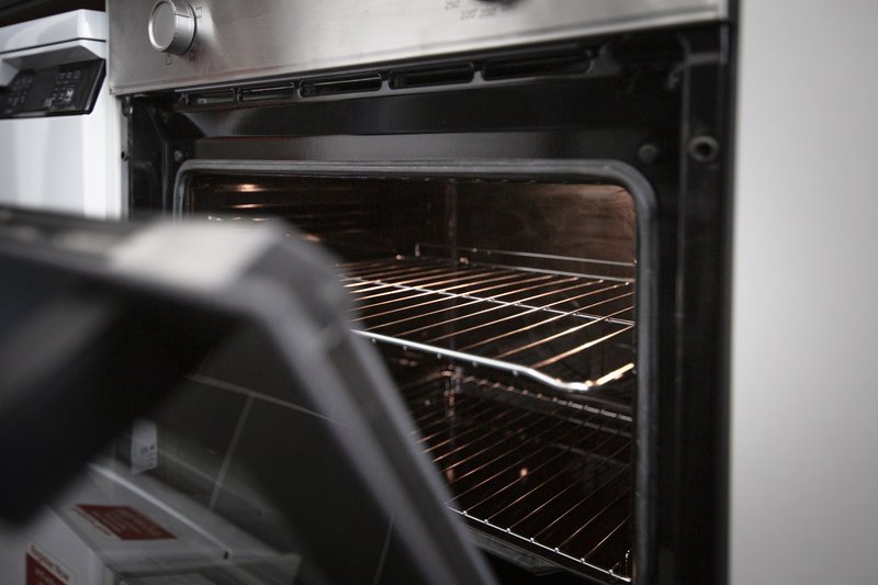 Built-in oven with open door showing interior racks and heating element