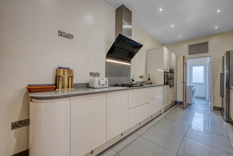 Modern kitchen with white cabinetry, stainless steel appliances, and tiled flooring