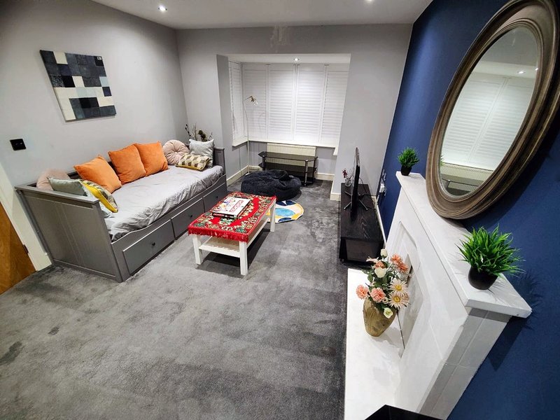 Modern living room with a sofabed, coffee table and a large mirror.
