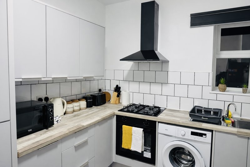 Modern kitchen with white cabinetry, subway tile backsplash, gas hob, and integrated appliances