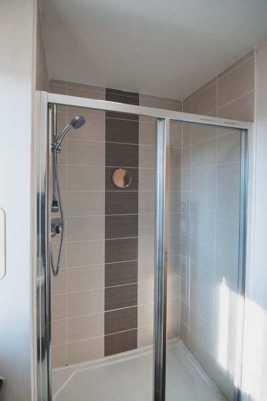 Modern bathroom with enclosed shower cubicle, tiled walls, and chrome fixtures