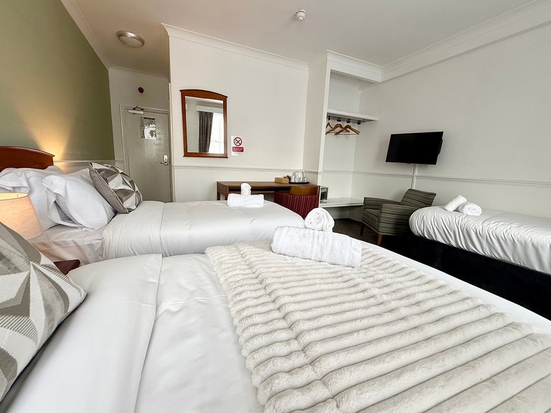 Relax in our Family Triple Room, ideal for up to three guests. It offers one double and one single bed, a private bathroom, Smart TV, fast Wi-Fi and tea and coffee facilities. Rooms may vary.