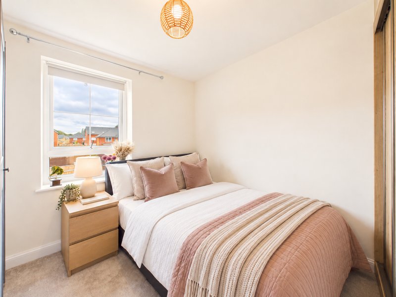 Bright bedroom with double bed, wooden nightstand, woven pendant light and window view