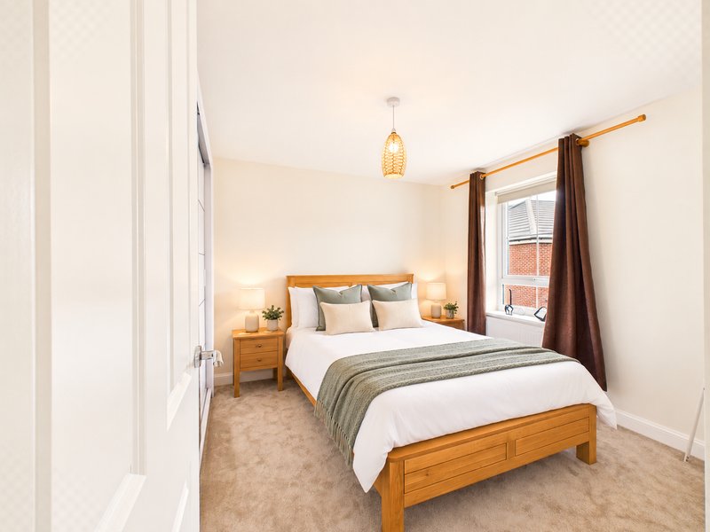 Bright bedroom with wooden four-poster bed, two bedside tables, pendant light and brown curtains