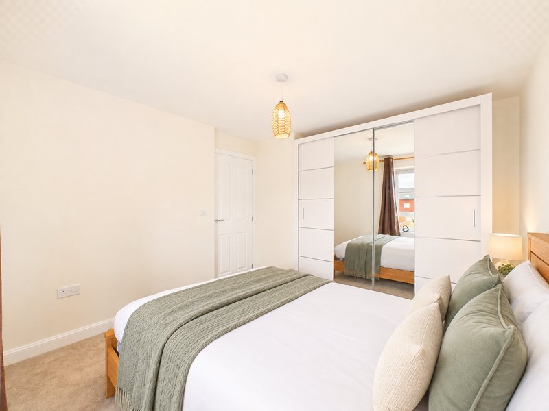 Bedroom with double bed, built-in wardrobe, pendant light and carpet flooring