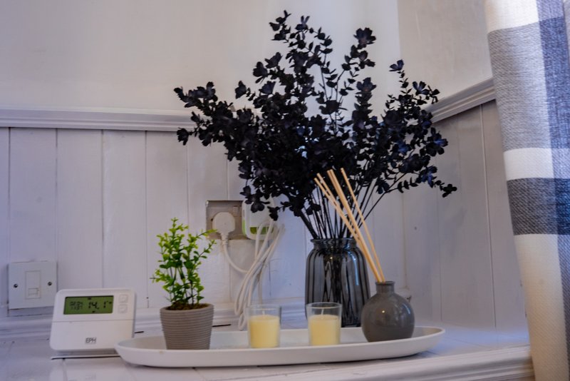 Bedroom shelf with dried flowers, potted plant, candles and decorative vases