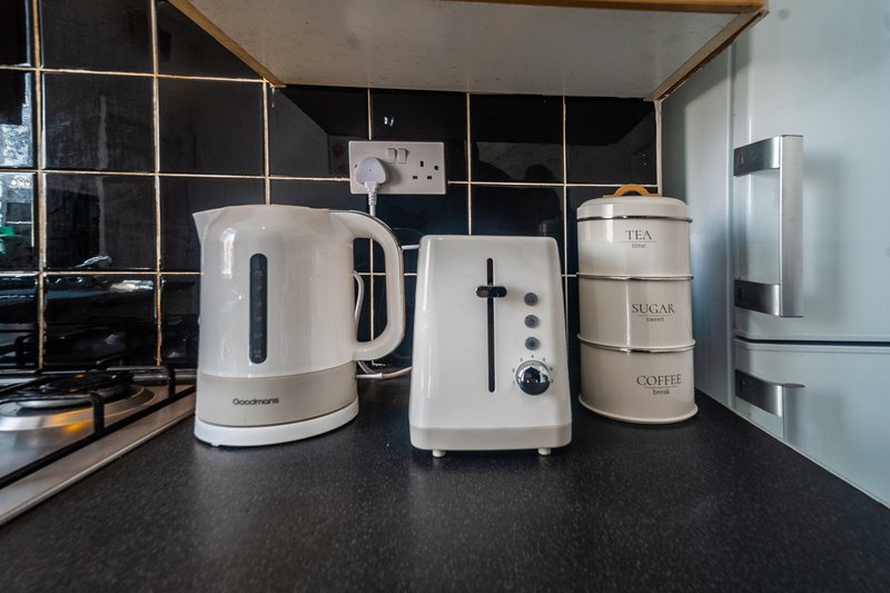 Kitchen counter with white kettle, toaster, and labeled storage containers