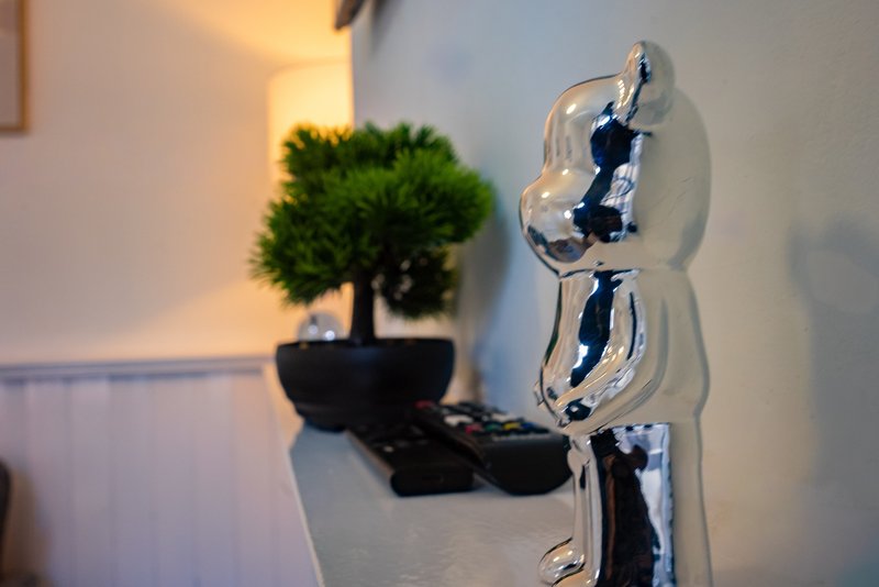 Modern shelf display with abstract glass sculpture and small potted bonsai tree