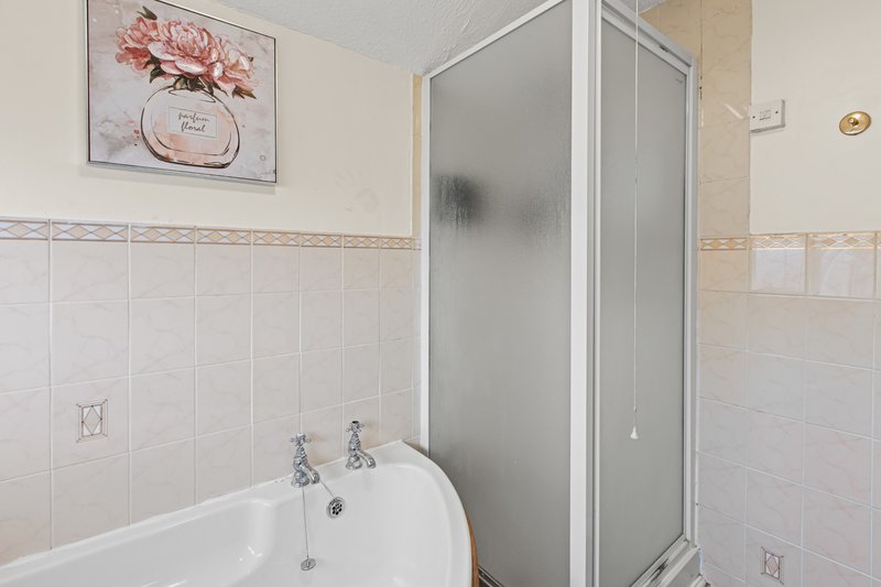 Bathroom with white suite, shower enclosure, and decorative wall art