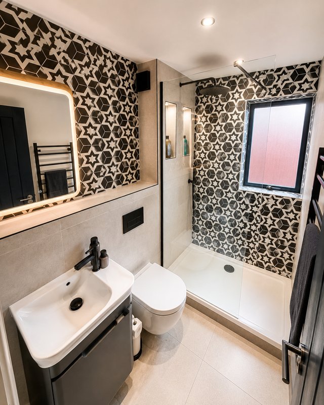 Modern bathroom with patterned wallpaper, sink, toilet, shower enclosure and mirror