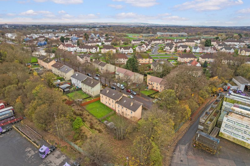 Aerial view of residential street with brick apartment buildings surrounded by trees and green space