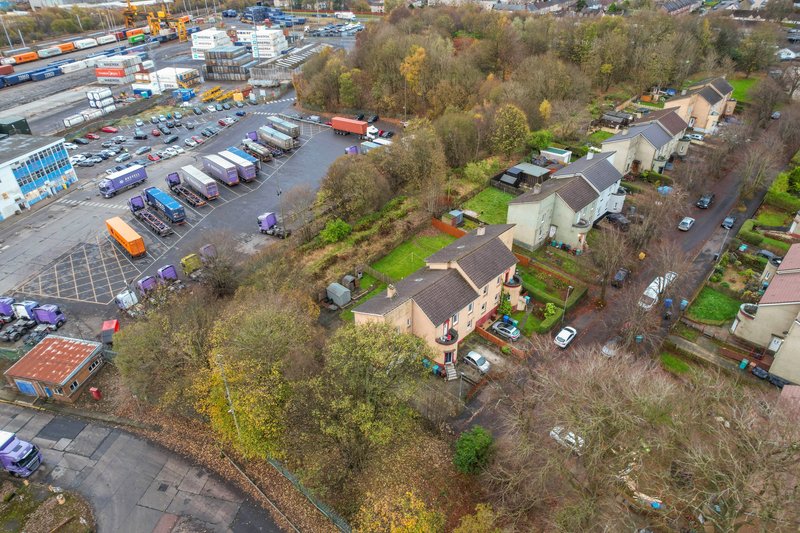 Aerial view of residential property with driveway, garden, and surrounding suburban neighborhood