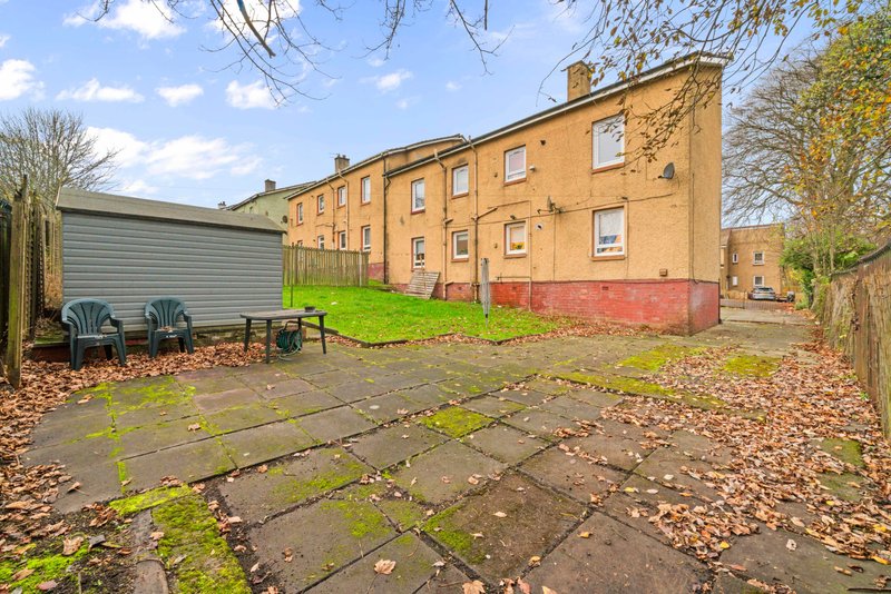 Brick residential building with garden patio, seating area and garden shed
