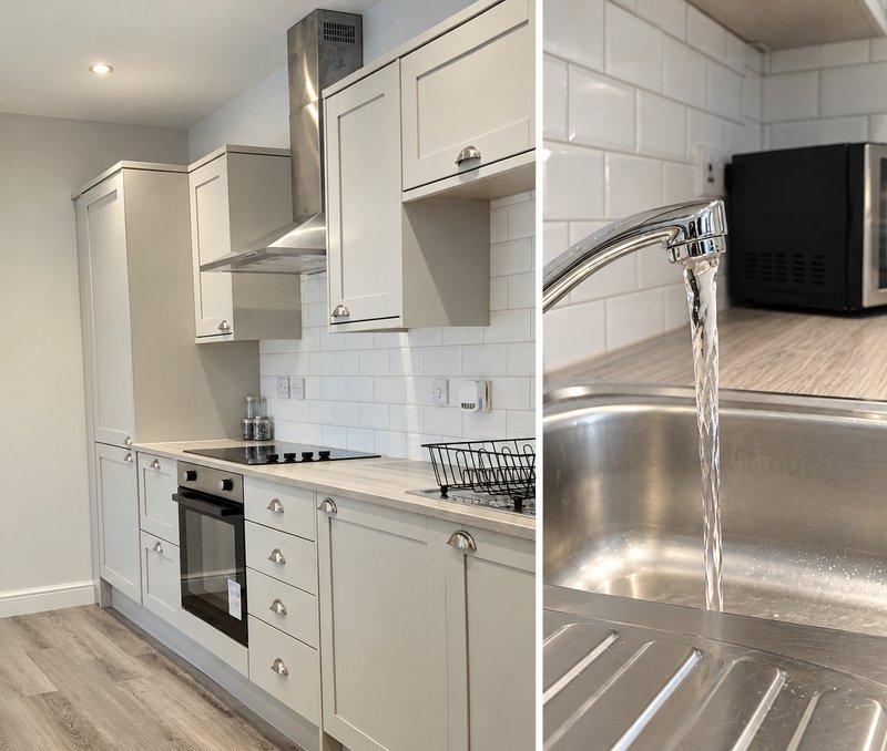 Modern kitchen with cream cabinets, stainless steel sink, white subway tile backsplash and built-in oven