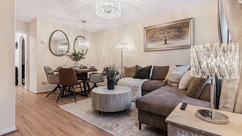 Open-plan living room with dining area, grey sofa, round coffee table and pendant lighting