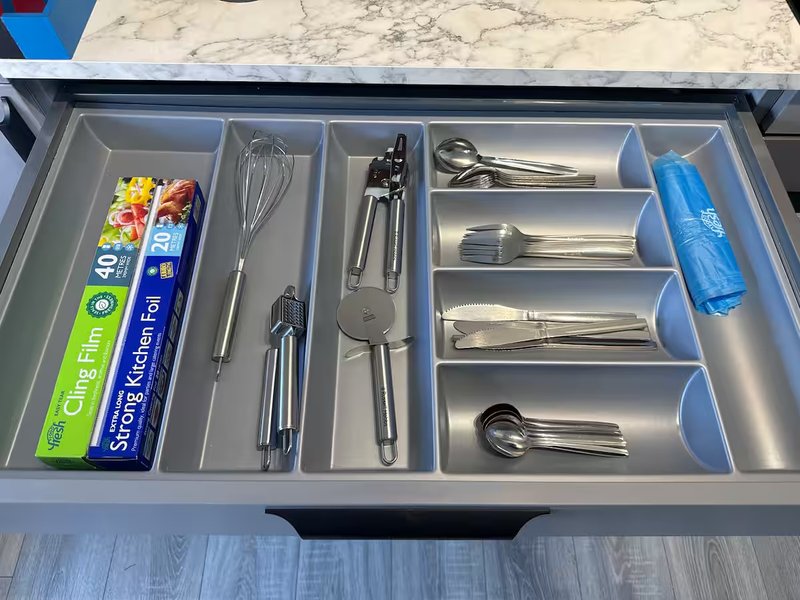 Kitchen drawer organizer with utensils, kitchen tools, and wrapped food items