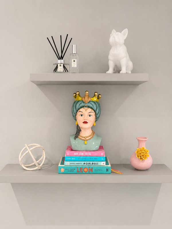 Two floating shelves with decorative items including figurines, books, and home accessories