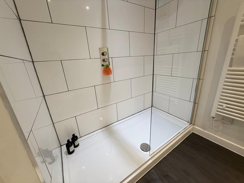 Modern bathroom shower enclosure with white subway tiles and glass door