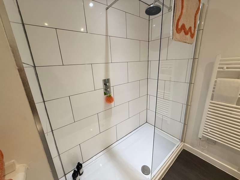 Modern bathroom with white subway tiled walk-in shower enclosure and chrome fixtures