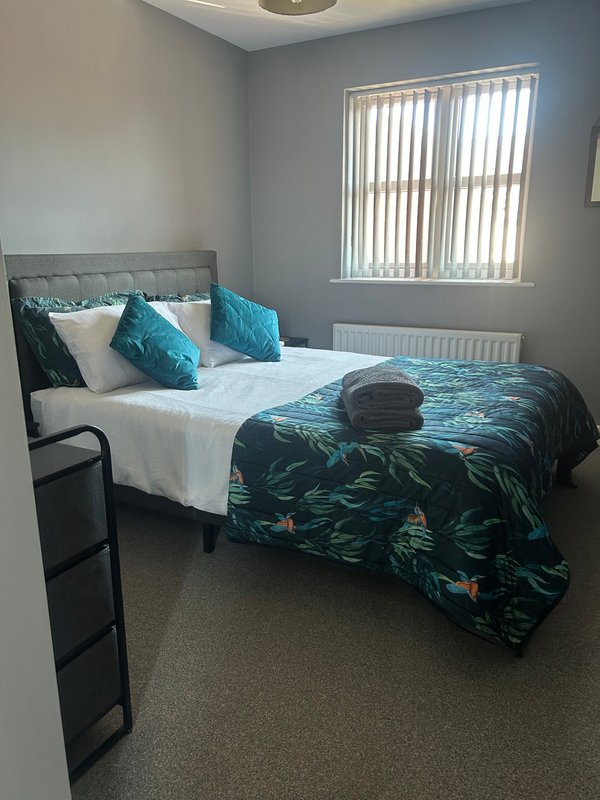 Modern bedroom with super-king bed, bedside cabinets and large hanging space.  Hairdryer and storage.
