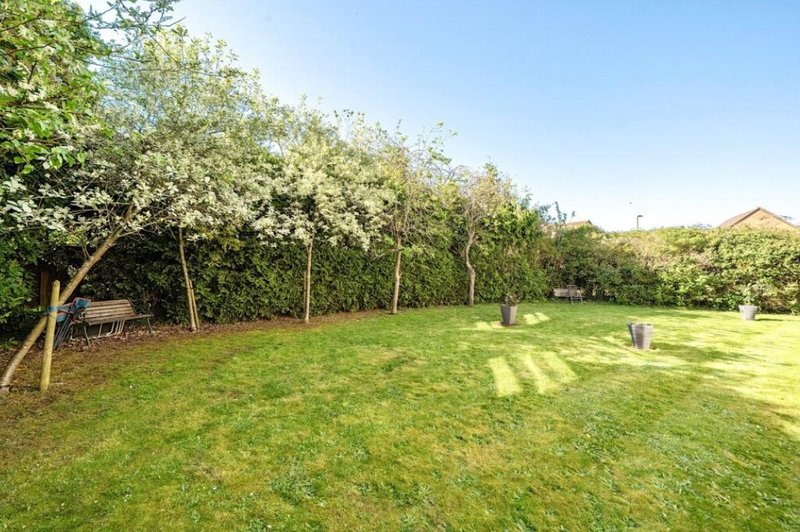 Large garden with mature trees, manicured lawn and garden furniture