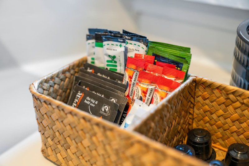 Woven basket containing packaged food items and groceries on white countertop