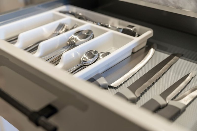 Open kitchen drawer with organized cutlery and utensil compartments