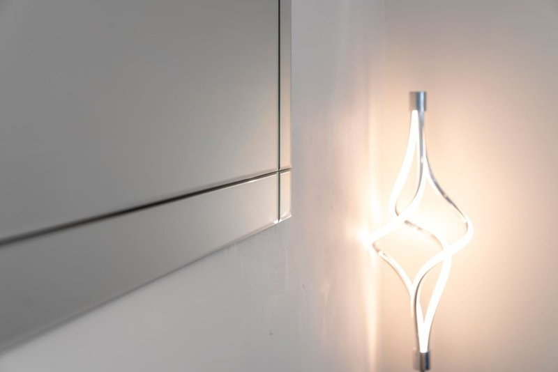 Modern white pendant light fixture suspended against plain white wall