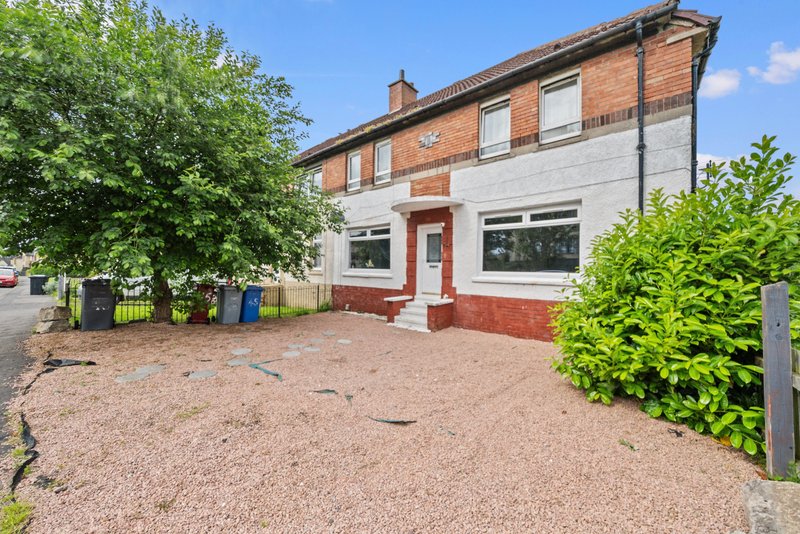 Red brick and rendered house with driveway, front garden and shrubs