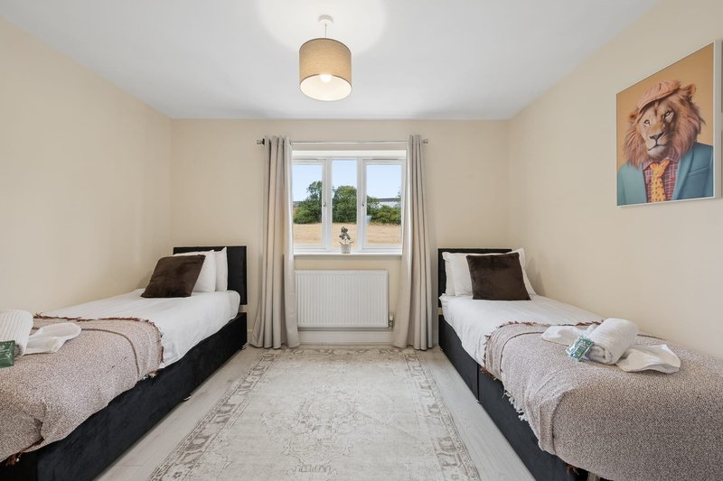 Twin bedroom with two single beds, window with countryside view, and wall artwork