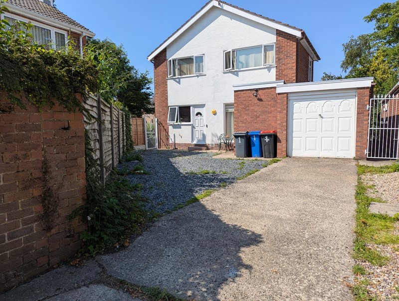 Two-storey brick and rendered house with driveway, garage and front garden