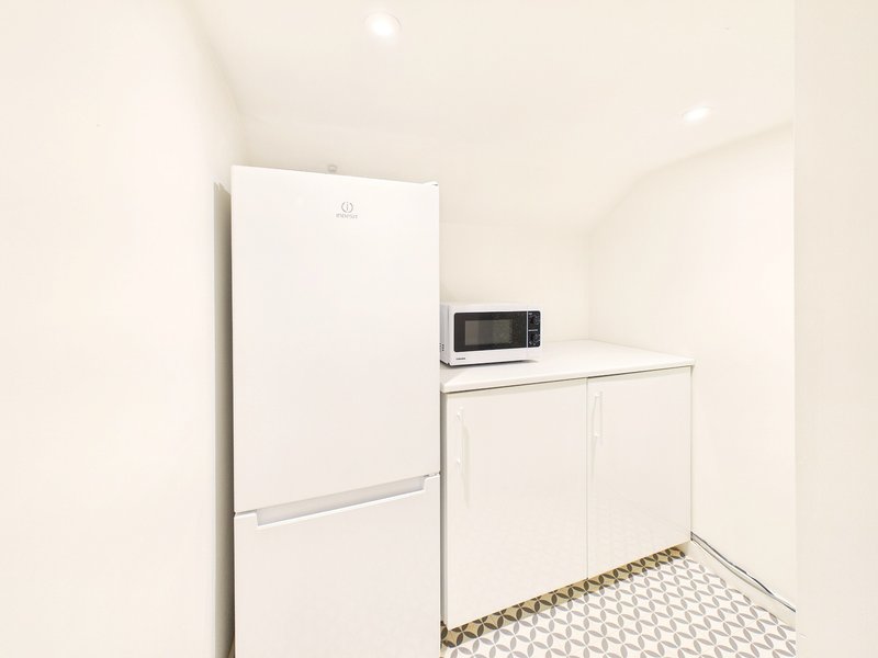 Modern kitchen with white refrigerator, microwave, and white cabinetry