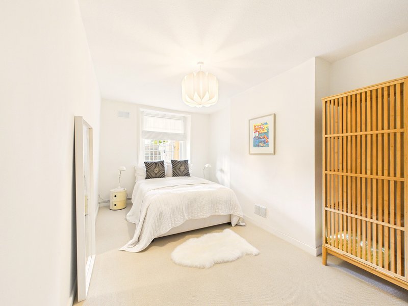 Bright bedroom with double bed, wooden wardrobe, pendant light and window seat