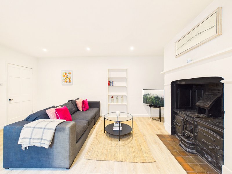 Modern living room with grey sofa, fireplace, wooden flooring and minimalist décor