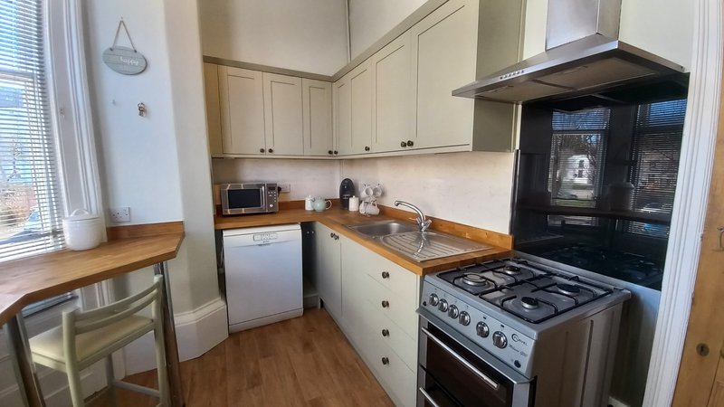 Kitchen with cream cabinets, wooden worktops, gas range, and stainless steel appliances