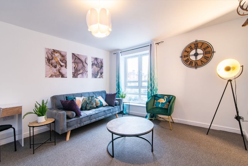 Modern living room with blue sofa, round coffee table, floor lamp and wall art