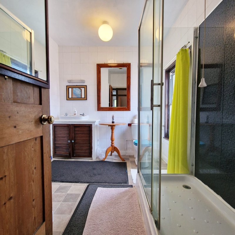 Bathroom with sink, mirror, shower enclosure and wooden vanity cabinet
