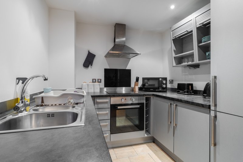 Modern kitchen with gray countertops, stainless steel appliances, and white cabinetry