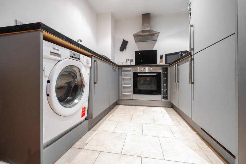 Modern kitchen with integrated appliances, washing machine, oven and extractor hood