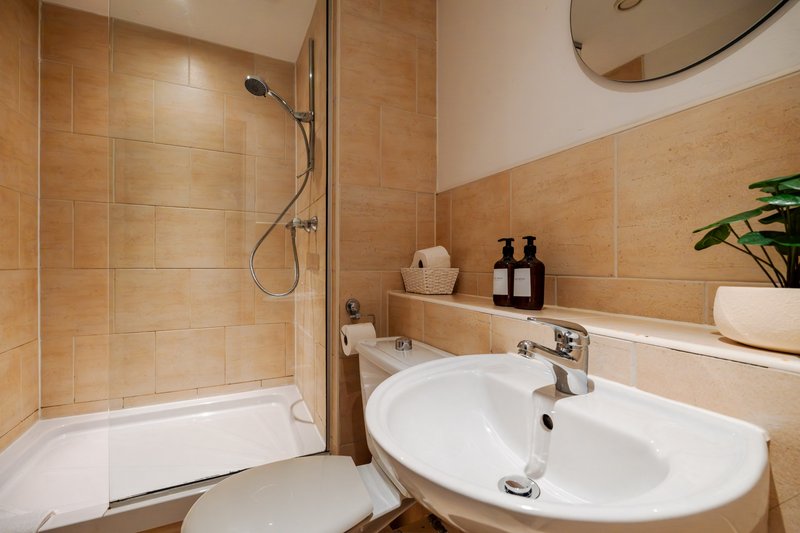 Modern bathroom with terracotta tiles, double sink, shower enclosure and mirror