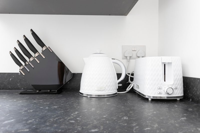Kitchen counter with knife block, white kettle, and white toaster
