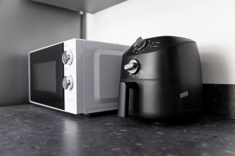 Kitchen counter with white microwave and black air fryer appliances