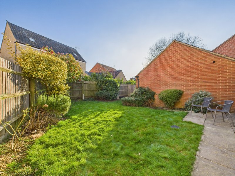 Spacious garden with lawn, patio area, garden chairs and brick property walls