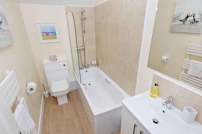 Modern bathroom with bath, shower enclosure, toilet, sink and heated towel rail
