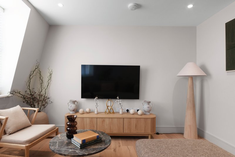 Modern living room with TV, wooden media console, sofa, floor lamp and decorative accessories