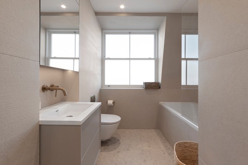 Modern bathroom with vanity sink, toilet, bathtub and large windows