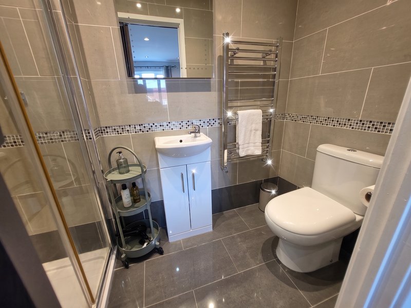 Modern bathroom with walk-in shower, vanity unit, toilet, heated towel rail and mirror cabinet